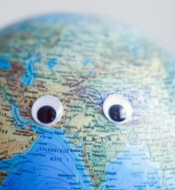 earth globe with googly eyes on gray background