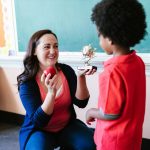 woman receiving best teacher prize from student